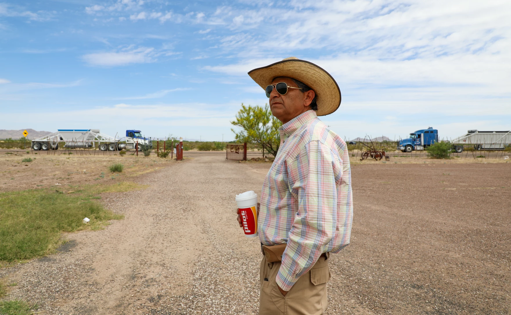 Javier Sanchez stands in his front yard in Lobo, Texas, as trucks delivering dirt to a new “man camp” for border wall construction workers drive past. “We lost all our tranquility,” he said.