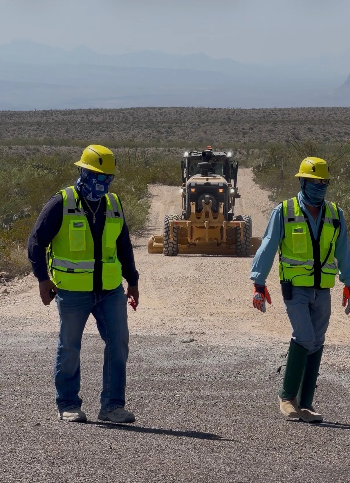 Masked contractors grade the road to Glenn Springs in Big Bend National Park.